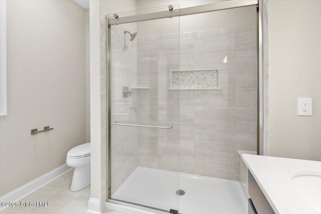 bathroom featuring tile patterned flooring, toilet, vanity, baseboards, and a stall shower