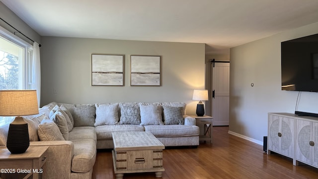 living room featuring a barn door and dark hardwood / wood-style floors