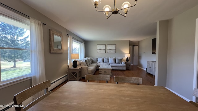 living room featuring a chandelier, baseboard heating, and dark wood-type flooring