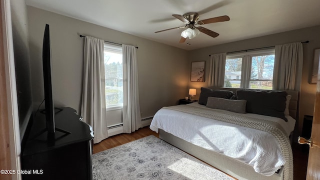 bedroom featuring ceiling fan, hardwood / wood-style floors, and a baseboard radiator