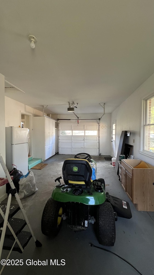 garage with white fridge and a garage door opener