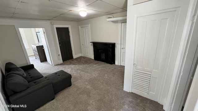 living room featuring a drop ceiling and light colored carpet