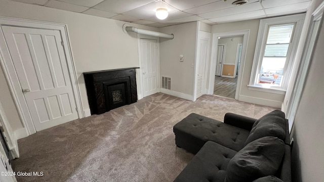 living room featuring light carpet and a drop ceiling