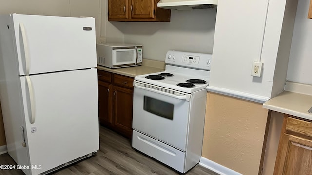 kitchen featuring white appliances, dark wood-type flooring, and extractor fan