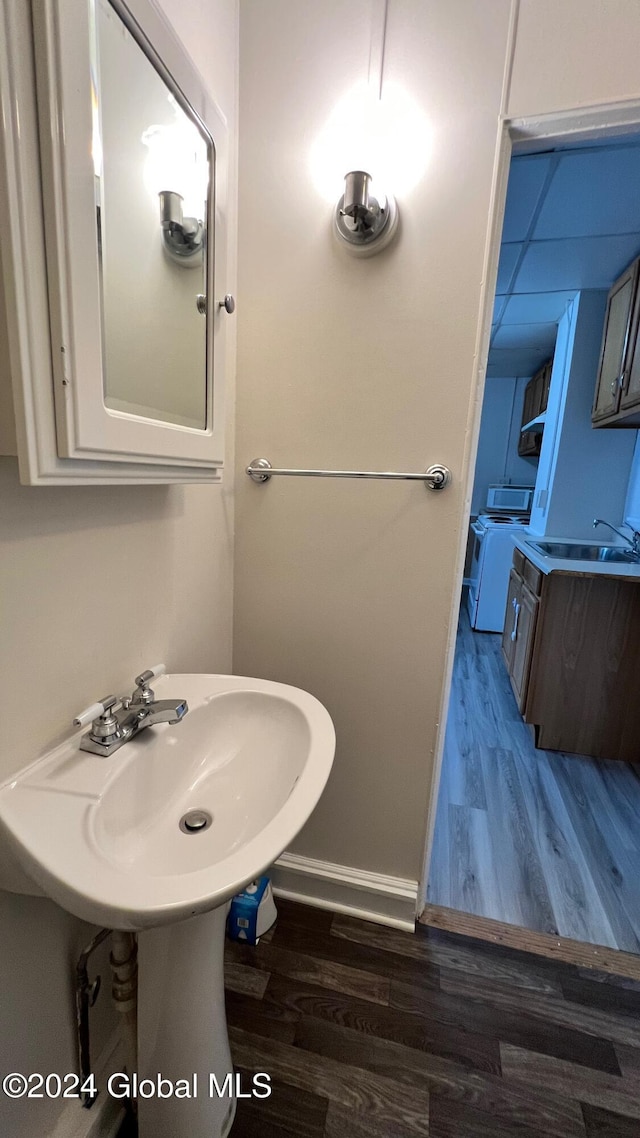 bathroom with hardwood / wood-style flooring, sink, and independent washer and dryer