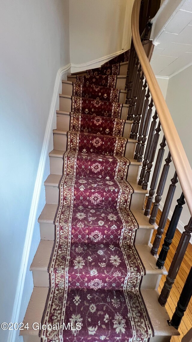 staircase featuring ornamental molding