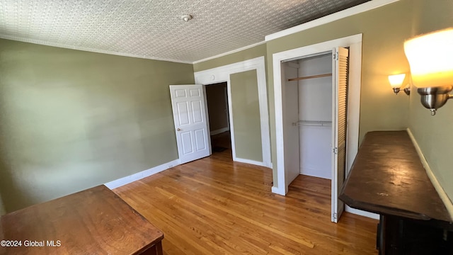 unfurnished bedroom featuring hardwood / wood-style floors and ornamental molding