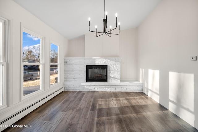 unfurnished living room featuring baseboard heating, dark hardwood / wood-style floors, a notable chandelier, lofted ceiling, and a fireplace