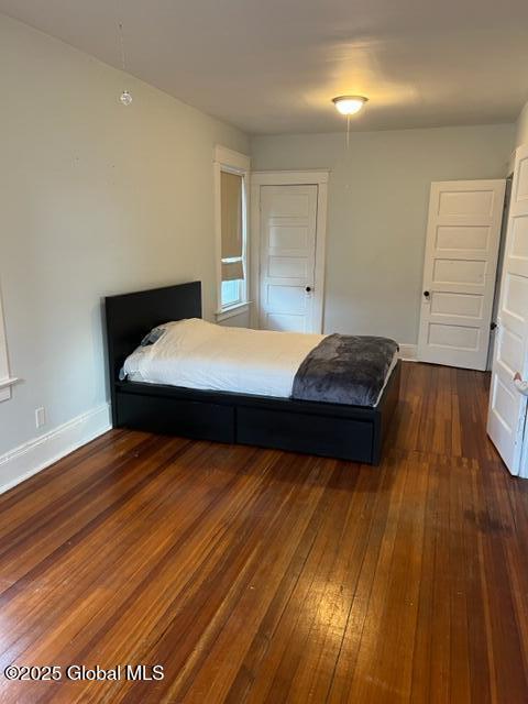 bedroom with dark hardwood / wood-style flooring