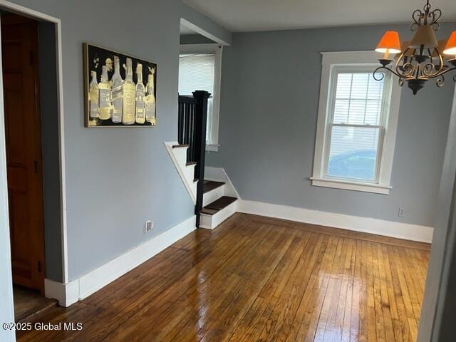 interior space with dark wood-type flooring and an inviting chandelier