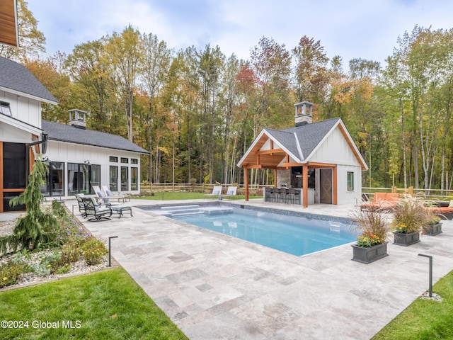 view of pool featuring an outdoor structure, a patio area, and an outdoor bar