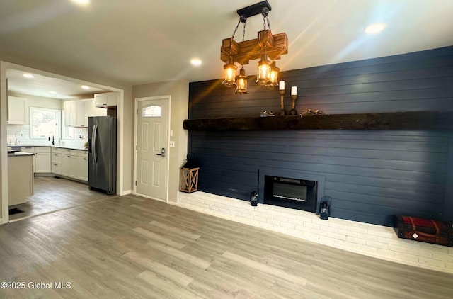 unfurnished living room with a fireplace, hardwood / wood-style flooring, and sink