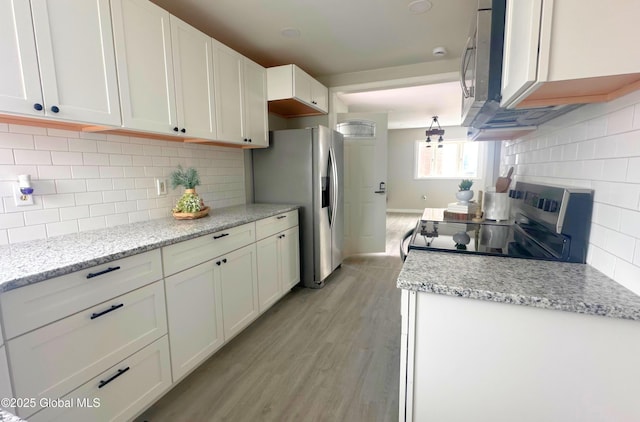 kitchen featuring decorative backsplash, stainless steel refrigerator with ice dispenser, range with electric cooktop, light stone counters, and white cabinets