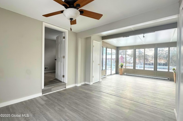 spare room featuring hardwood / wood-style flooring, ceiling fan, lofted ceiling, and baseboard heating