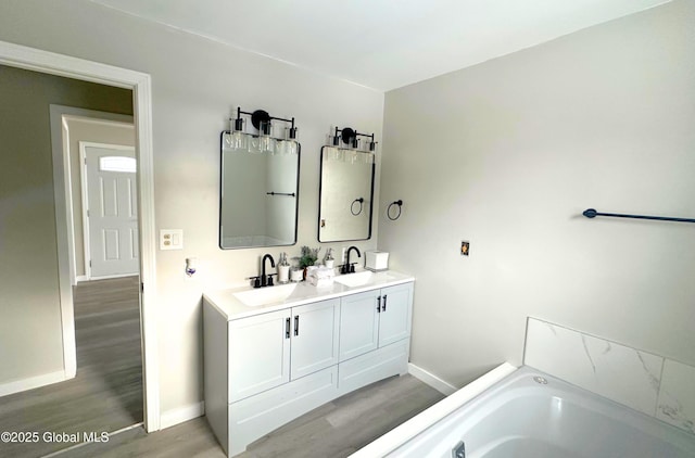 bathroom featuring a bathing tub, vanity, and hardwood / wood-style floors