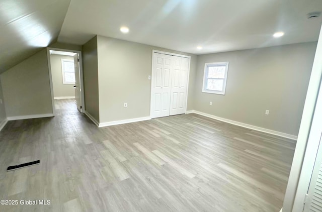 interior space with light wood-type flooring and vaulted ceiling