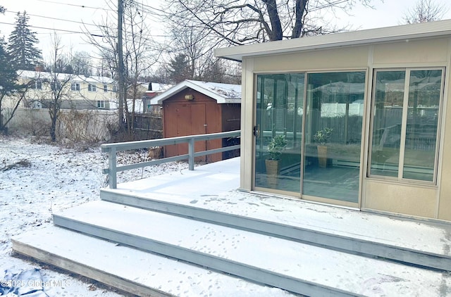 snow covered deck featuring a storage unit