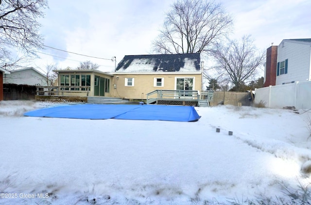 snow covered property featuring a sunroom and a pool side deck