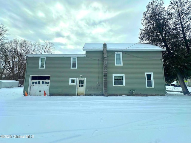 snow covered property featuring a garage