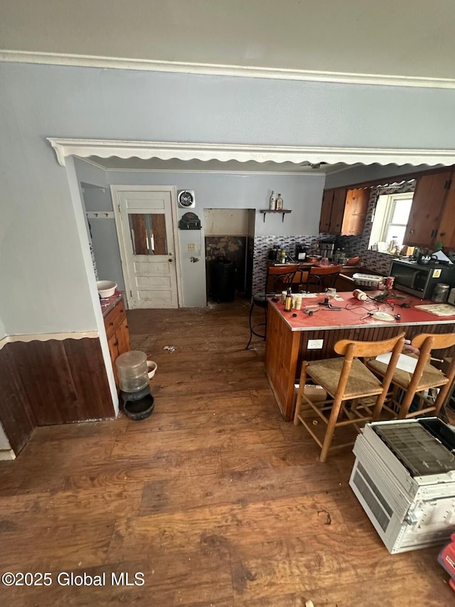 kitchen with hardwood / wood-style floors, backsplash, and crown molding