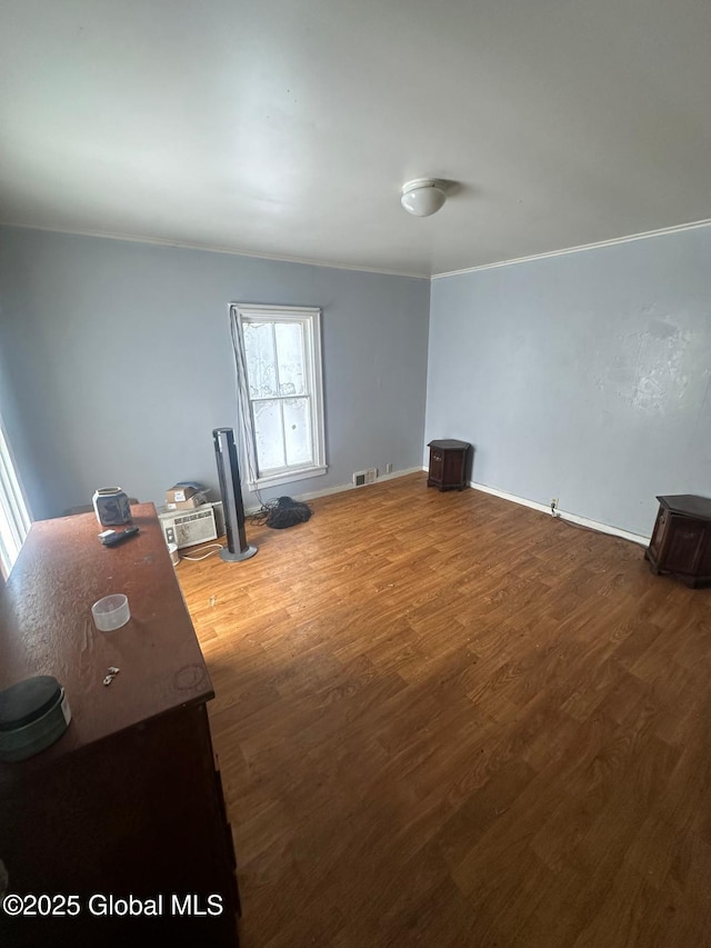 empty room with hardwood / wood-style flooring and crown molding