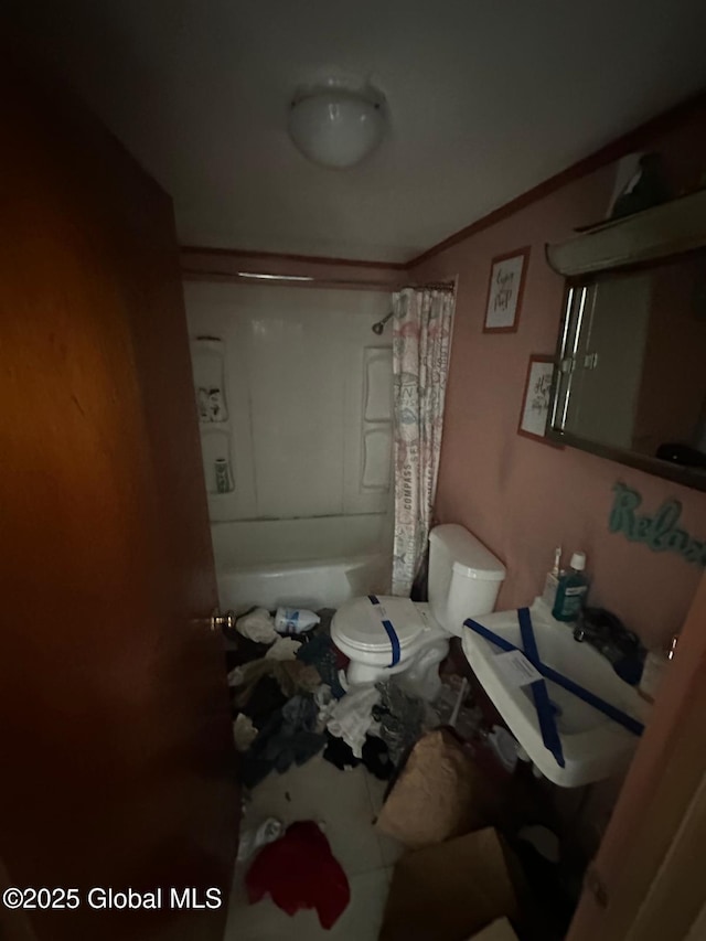 interior space featuring toilet and shower / bath combo with shower curtain