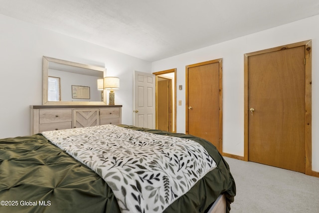 bedroom with two closets and light colored carpet