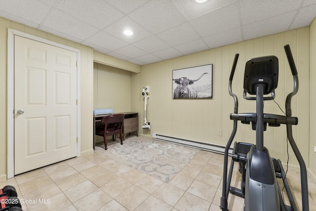 workout room with a paneled ceiling and light tile patterned floors