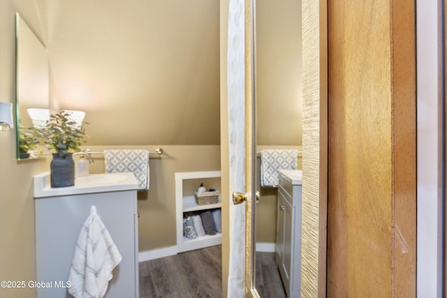 bathroom with vaulted ceiling, wood-type flooring, and vanity