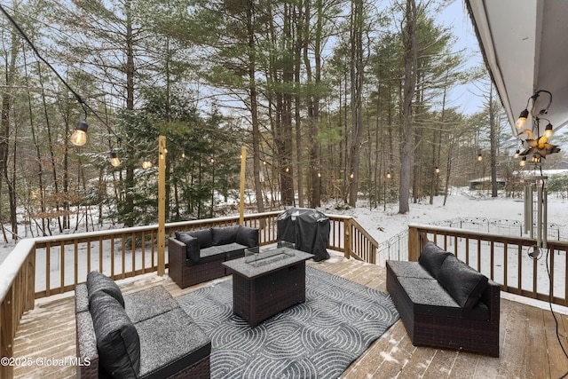 snow covered deck featuring an outdoor living space with a fire pit and grilling area