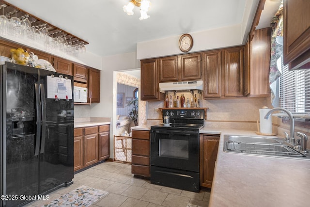 kitchen featuring light tile patterned flooring, sink, and black appliances