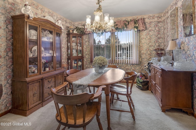 dining room with light colored carpet and a chandelier