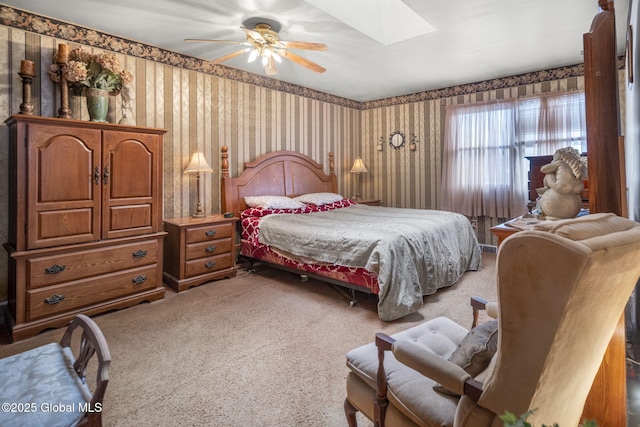 bedroom with ceiling fan, a skylight, and carpet floors