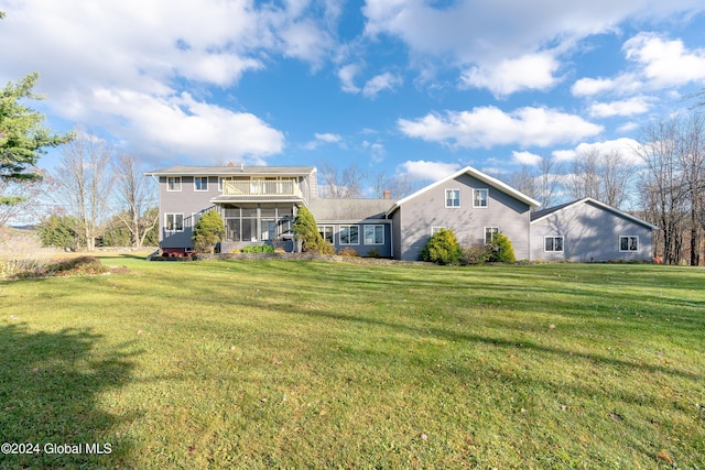 back of property with a lawn and a sunroom