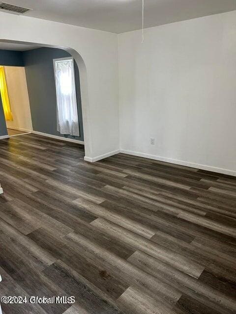 spare room featuring dark wood-type flooring