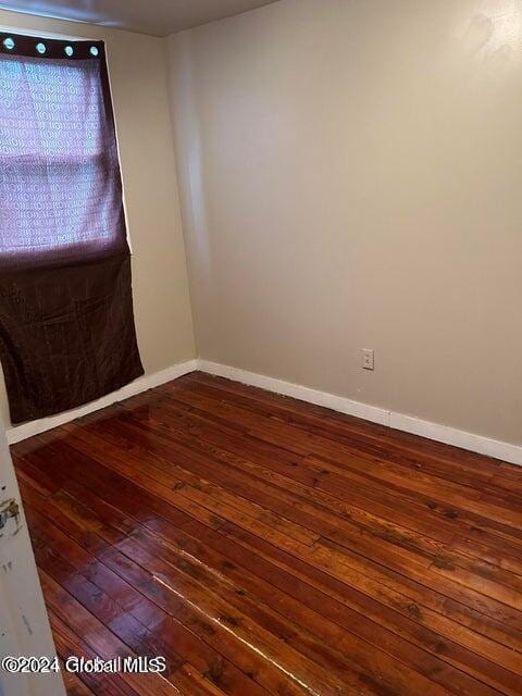 unfurnished room with dark hardwood / wood-style floors