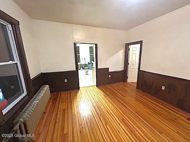 empty room featuring radiator heating unit and wood-type flooring