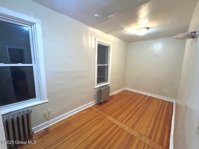 unfurnished room with radiator heating unit