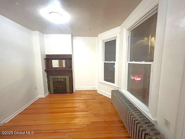 interior space with radiator heating unit and light hardwood / wood-style floors