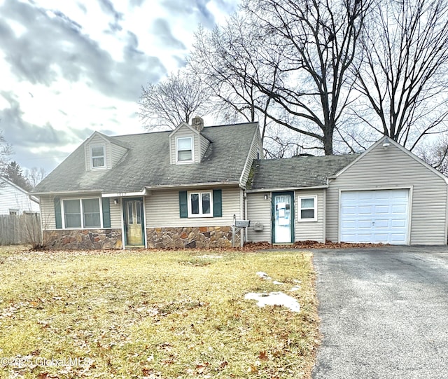 cape cod home with a garage and a front lawn