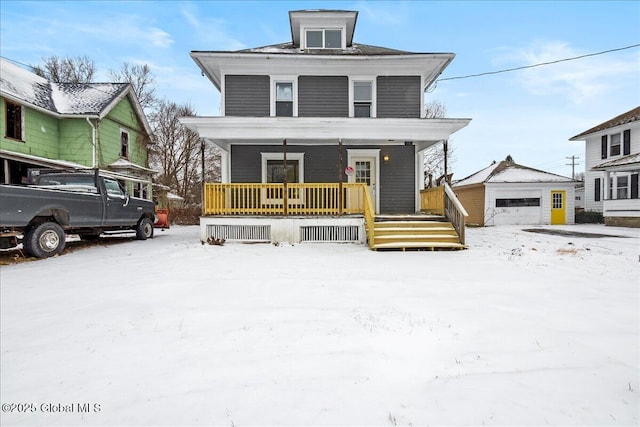 view of front of home with a porch, a garage, and an outbuilding