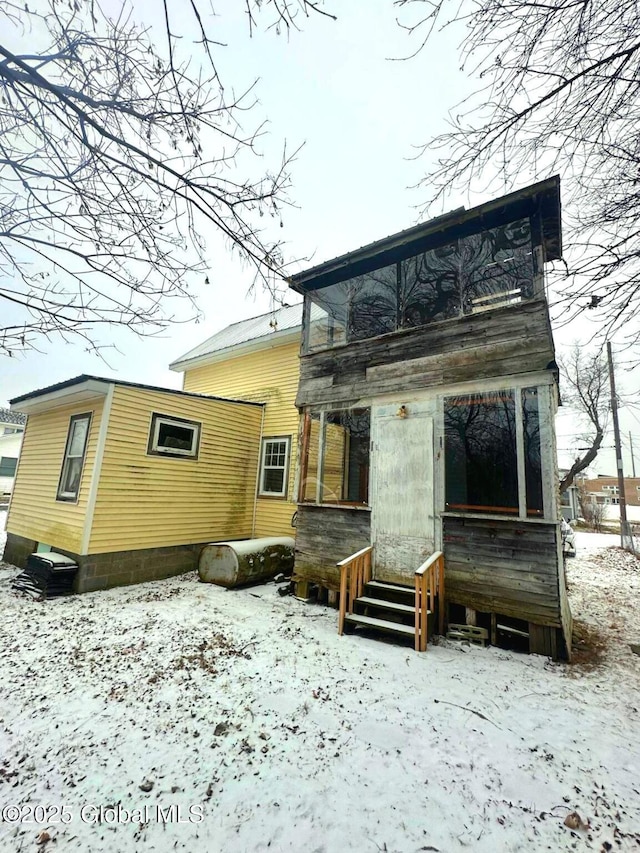 snow covered rear of property featuring a balcony