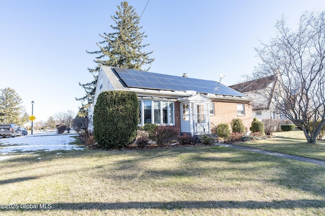 view of front of property with solar panels and a front yard