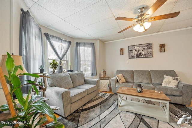 living room featuring a drop ceiling and ceiling fan