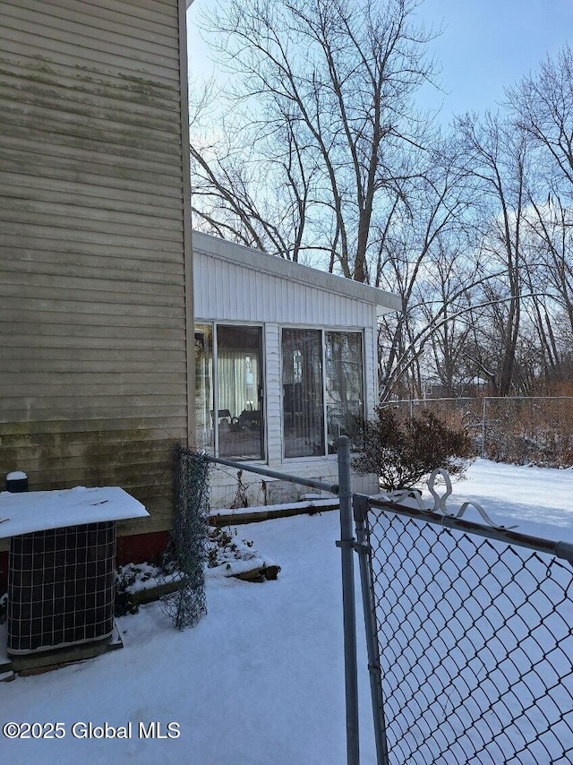 snow covered property featuring central AC unit