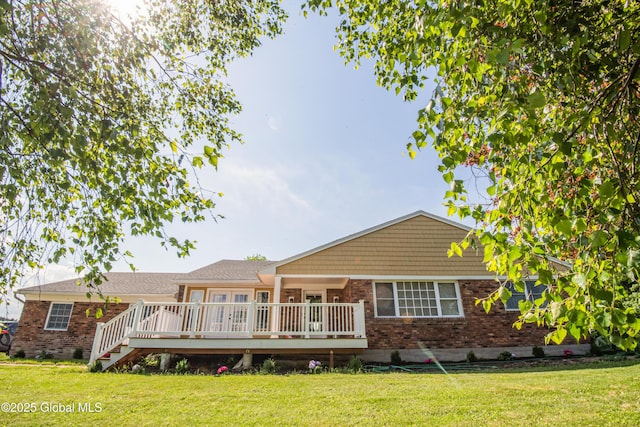 rear view of house featuring a lawn and a deck