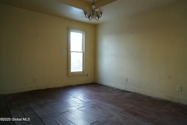 unfurnished room featuring a chandelier