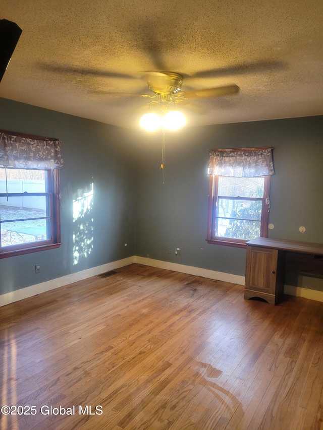 unfurnished room with wood-type flooring, a textured ceiling, and ceiling fan