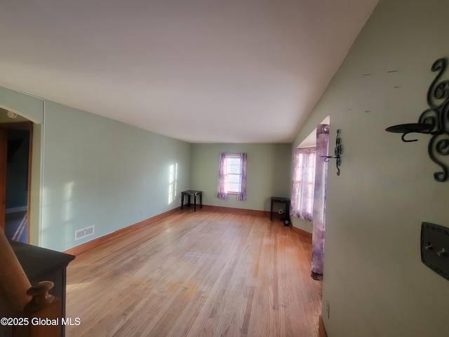 unfurnished living room featuring lofted ceiling and light wood-type flooring