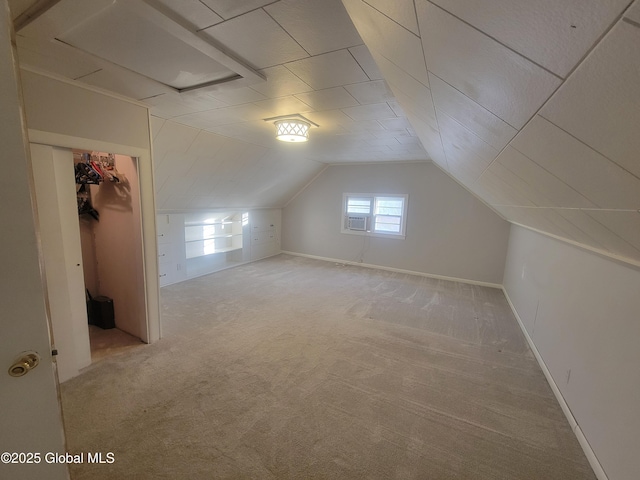 additional living space with built in shelves, cooling unit, light colored carpet, and vaulted ceiling